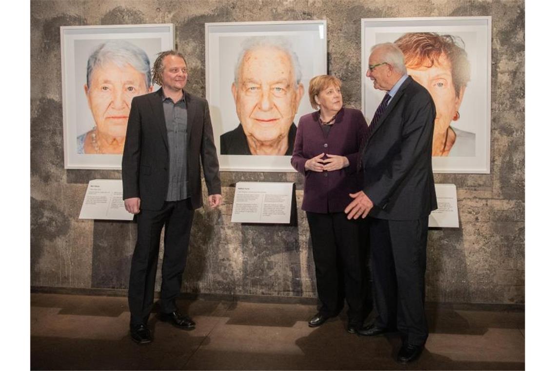 Der Künstler Martin Schoeller (l), der Holocaust-Überlebende Naftali Fürst und Bundeskanzlerin Angela Merkel (CDU) bei der Eröffnung der Ausstellung „Survivors - Faces of Life after the Holocaust“ in Essen. Foto: Rolf Vennenbernd/dpa