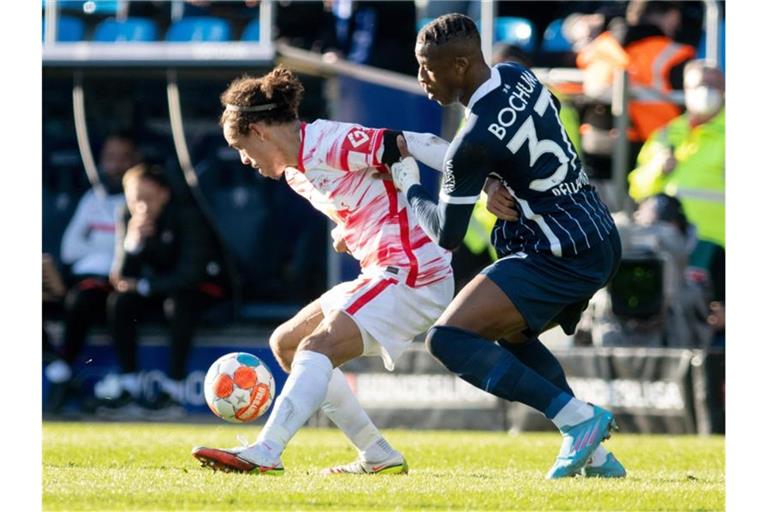 Der Leipziger Yussuf Poulsen (l) schirmt den Ball gegen Armel Bella Kotchap ab. Foto: Bernd Thissen/dpa