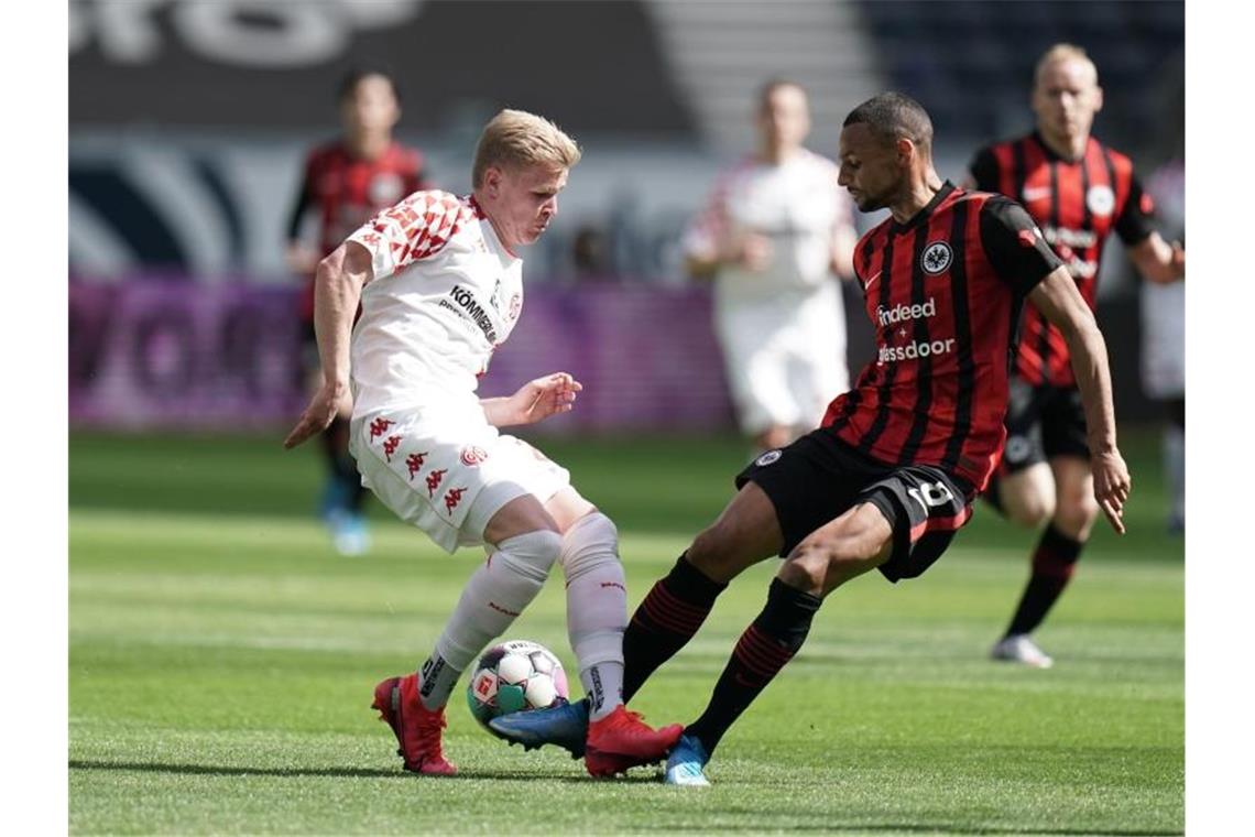 Der Mainzer Jonathan Burkhardt (l) und der Frankfurter Djibril Sow kämpfen resolut um den Ball. Foto: Thomas Frey/dpa