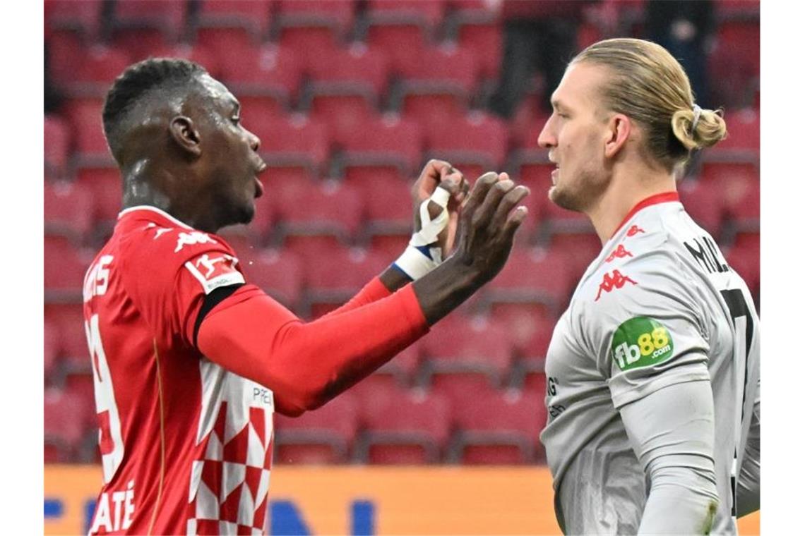 FC Bayern hält BVB auf Distanz - Dämpfer für Hoffenheim Der Mainzer Kapitän Moussa Niakhate (l) jubelt mit Torwart Robin Zentner über dessen gehaltenen Elfmeter. Foto: Torsten Silz/dpa