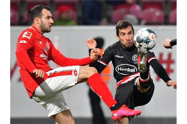Der Mainzer Levin Ötztunali (l) und Düsseldorfs Markus Suttner kämpfen um den Ball. Foto: Torsten Silz/dpa