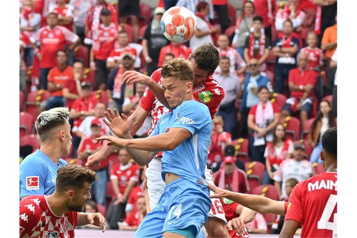 FC Bayern erobert Bundesliga-Spitze - Gladbach-Rückschlag Der Mainzer Stefan Bell und Freiburgs Yannik Keitel steigen zum Kopfball hoch. Foto: Torsten Silz/dpa