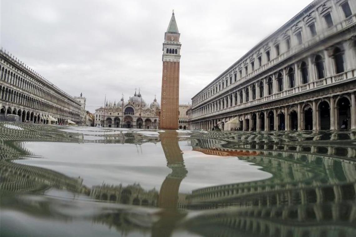 Der Markusturm spiegelt sich im Hochwasser, das den Markusplatz bedeckt. Foto: Luca Bruno/AP/dpa