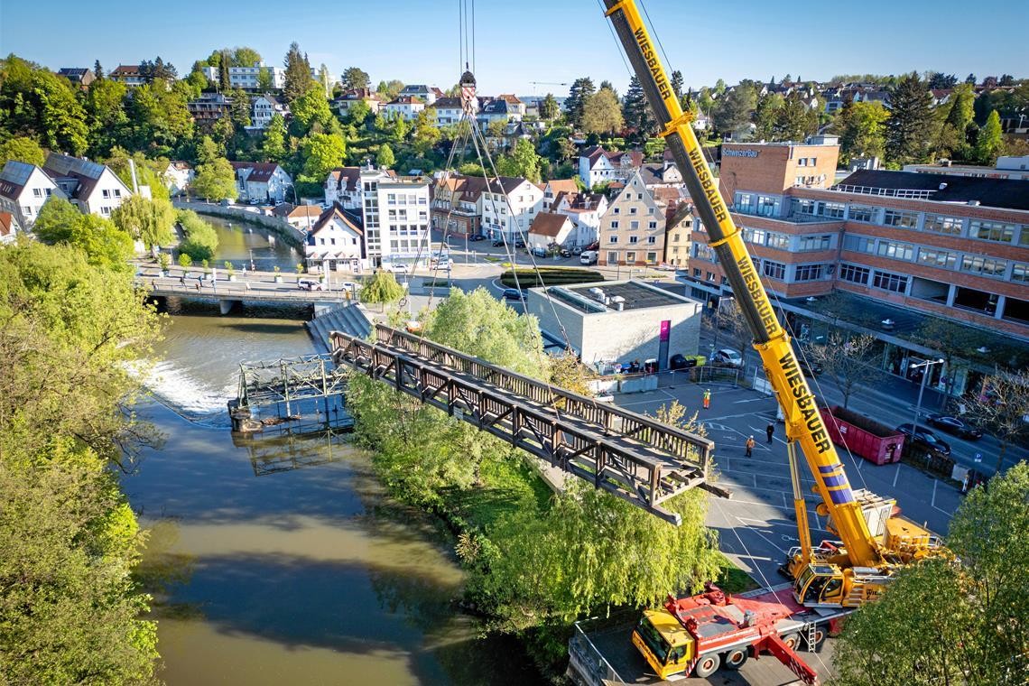 Der Murrsteg in Backnang ist jetzt abgebaut Der marode Holzsteg wird am Montagmorgen komplett aus dem Fundament gehoben. Fotos: Alexander Becher