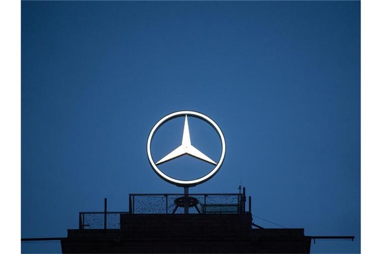 Der Mercedes-Stern leuchtet in der Dunkelheit. Foto: Marijan Murat/dpa/Archivbild