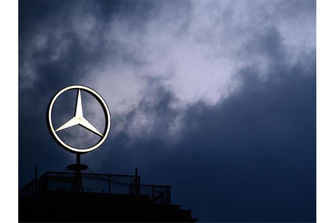 Der Mercedes-Stern vor dem dunklen Himmel. Foto: Sebastian Gollnow/dpa