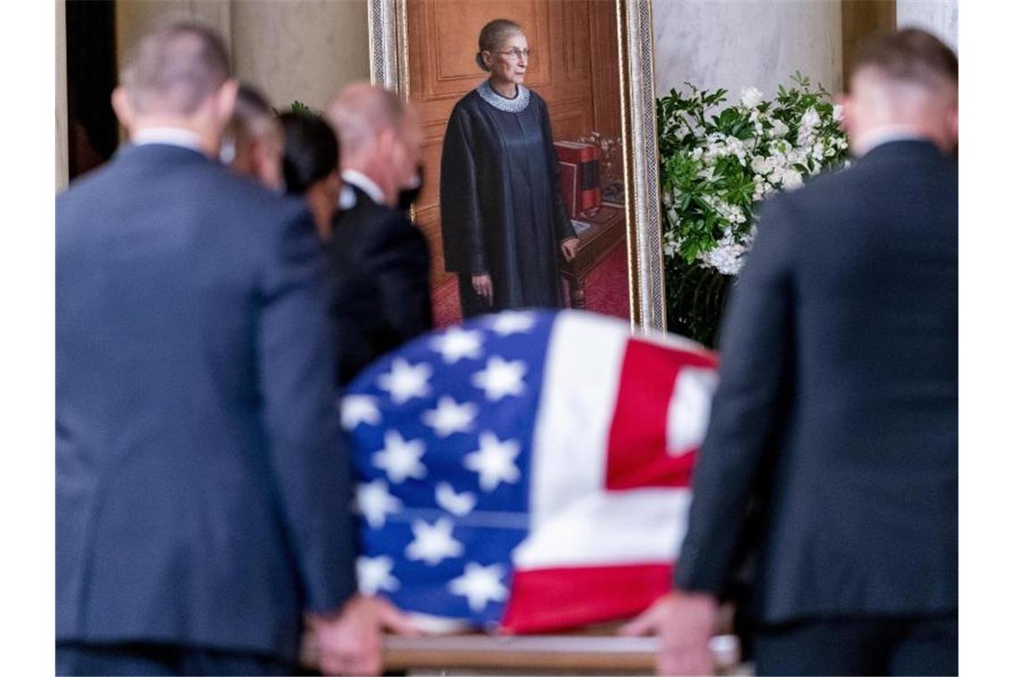 Der mit einer amerikanischen Flagge bedeckte Sarg mit dem Leichnam der US-Richterin Ruth Bader Ginsburg wird in den Supreme Court getragen. Foto: Andrew Harnik/AP Pool/dpa