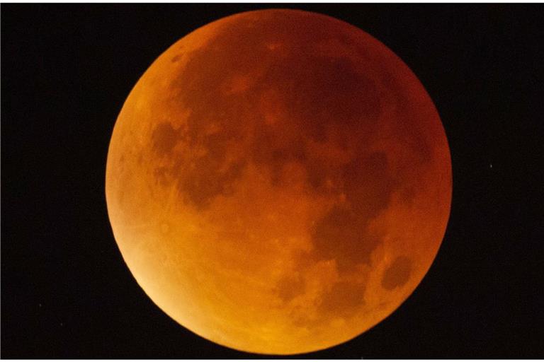 Der Mond erscheint am 21. Januar über Stuttgart während einer Mondfinsternis fast vollständig in einem rötlichen Farbton. Ursache des roten Schimmers sind die roten Anteile des Spektrums der Sonnenstrahlen, die durch die Erdatmosphäre in den Kernschatten der Erde abgelenkt werden.