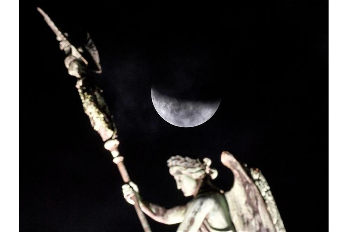 Der Mond ist während der partiellen Mondfinsternis hinter der Quadriga des Brandenburger Tors zu sehen. Foto: Britta Pedersen