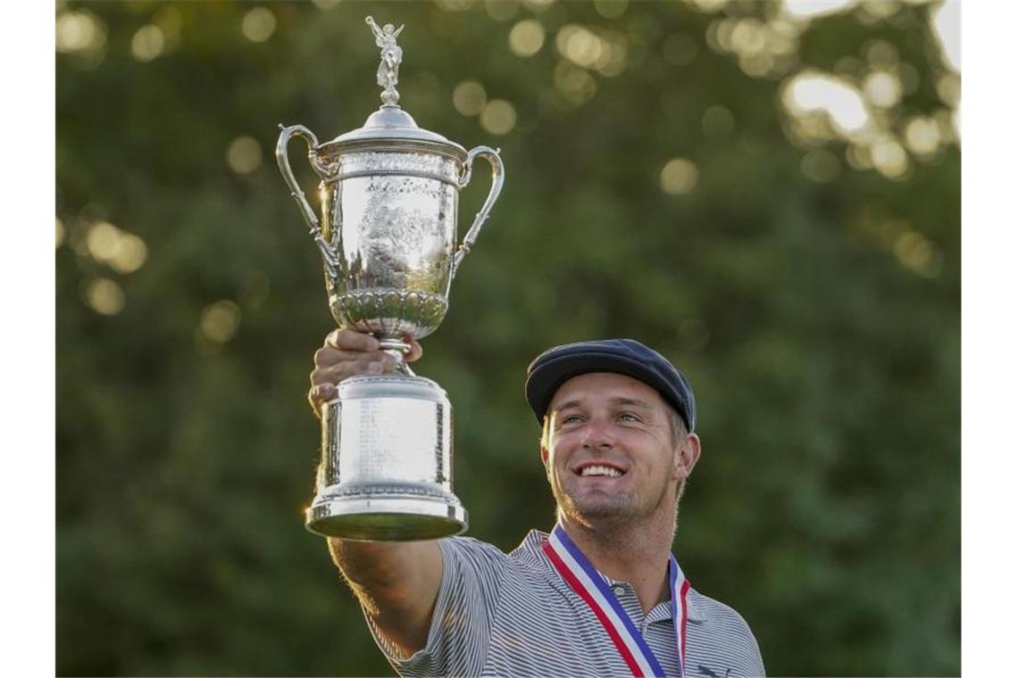 Der muskulöse Golfer Bryson DeChambeau aus den USA hält nach dem Sieg der US Open seine Trophäe in die Höhe. Foto: John Minchillo/AP/dpa