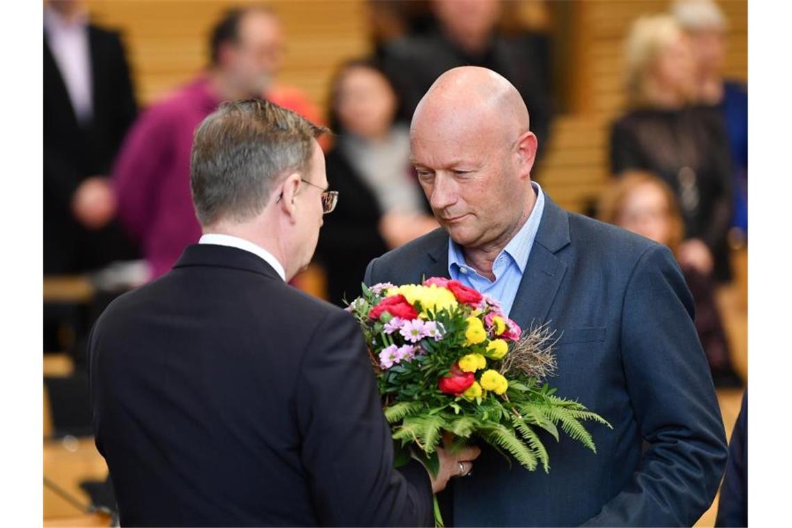 Der neu gewählte Ministerpräsident Bodo Ramelow (l, Die Linke), nimmt nach dem dritten Wahlgang die Glückwünsche des bisher geschäftsführenden Ministerpräsidenten Thomas Kemmerich (FDP) entgegen. Foto: Martin Schutt/dpa-Zentralbild/dpa