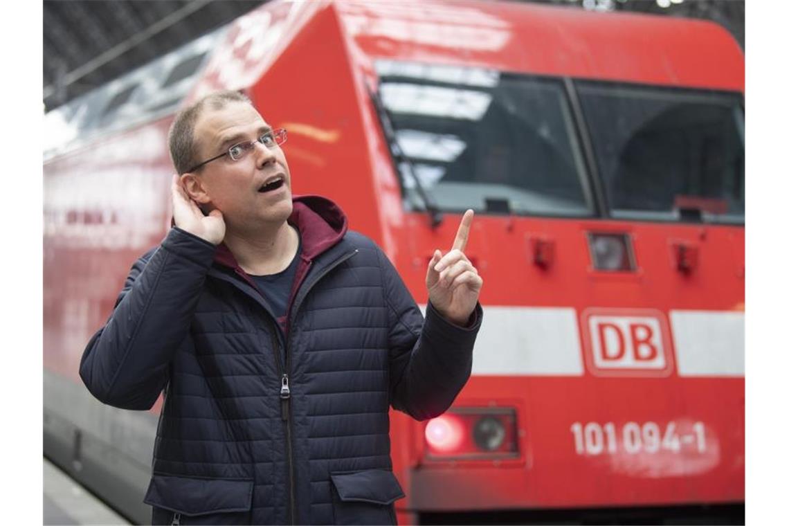 Neuer Bahnansager wünscht Fahrgästen Gesundheit Der neue Bahnansager Heiko Grauel steht auf dem Hauptbahnhof Frankfurt vor einem Zug. Foto: Boris Roessler/dpa/Archivbild