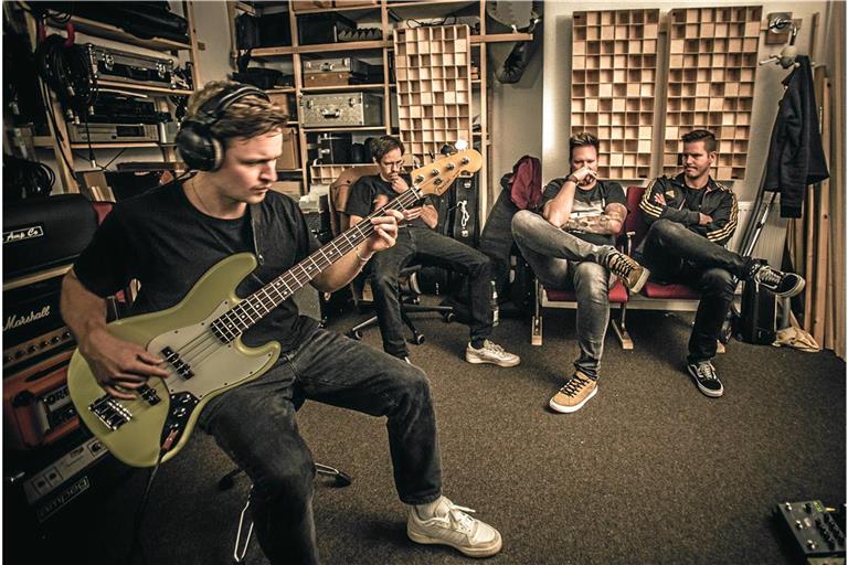 Der neue Bassist Peter Graulich (links) spielt konzentriert im Proberaum in Backnang. Marcus Schneider, Denis Deschner und Heiko Peter hören dem Kollegen zu. Foto: Nadine Rapczynski