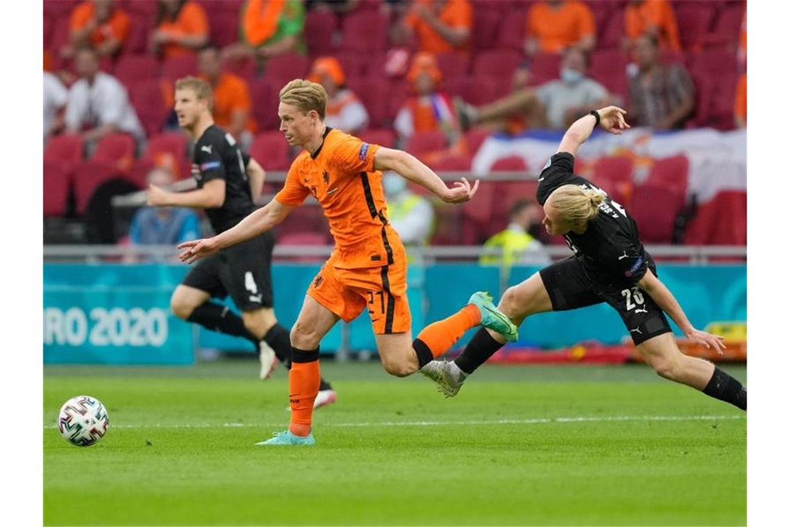 Der Niederländer Frenkie de Jong (M.) gewinnt den Zweikampf mit Xaver Schlager (r). Foto: Peter Dejong/AP Pool/dpa