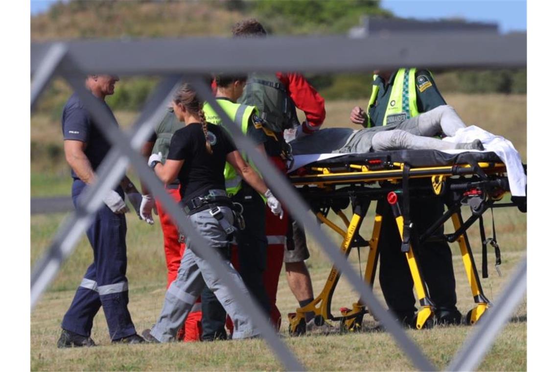 Der Notfalldienst betreut eine verletzte Person. Foto: Alan Gibson/New Zealand Herald/dpa