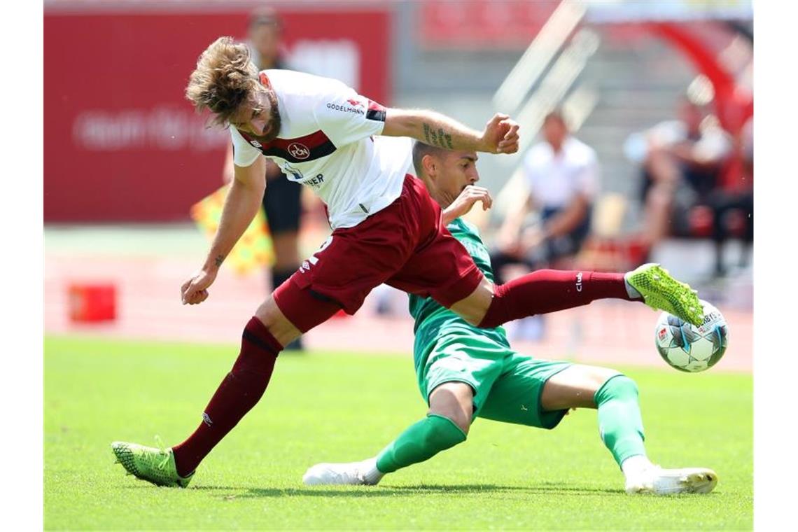 Der Nürnberger Enrico Valentini verliert den Zweikampf mit Kenny Prince Redondo. Foto: Alexander Hassenstein/getty/Pool/dpa