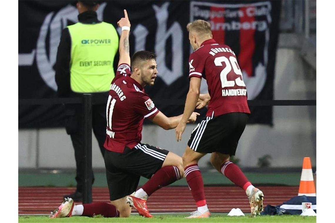 Cool gegen den KSC: 1. FC Nürnberg holt zweiten Saisonsieg Der Nürnberger Erik Shuranov (l) jubelt mit seinem Mannschaftskollegen Tim Handwerker über seinen Treffer zum 2:0. Foto: Daniel Karmann/dpa