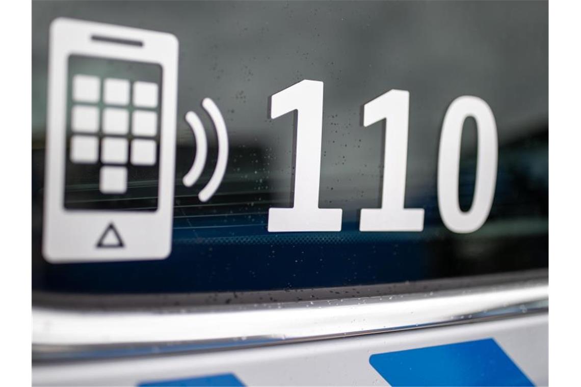 Der Nummer des Polizeinotrufs 110 steht auf der Scheibe eines Polizeifahrzeugs. Foto: Daniel Karmann/dpa/Symbolbild