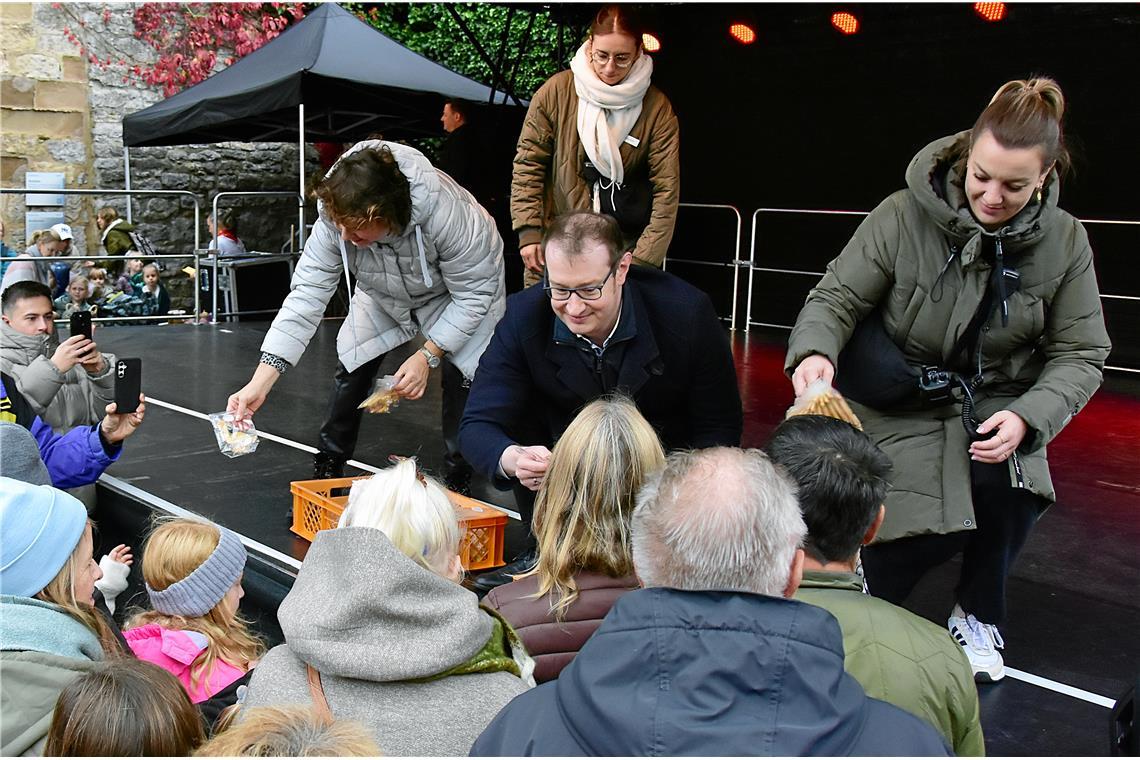 Der Oberbürgermeister und Mitglieder des Stadtrats verteilen Mürbeteig-Gänschen....