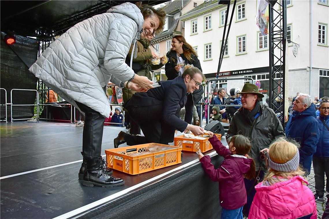 Der Oberbürgermeister und Mitglieder des Stadtrats verteilen Mürbeteig-Gänschen....