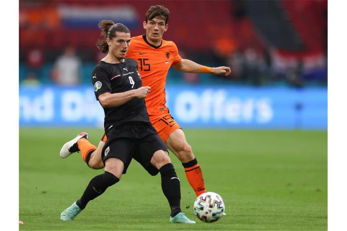 Begeisternde Niederländer vorzeitig im Achtelfinale Der Österreicher Marcel Sabitzer (l) schirmt den Ball gegen Marten de Roon ab. Foto: Dean Mouhtaropoulous/Getty Pool/AP/dpa