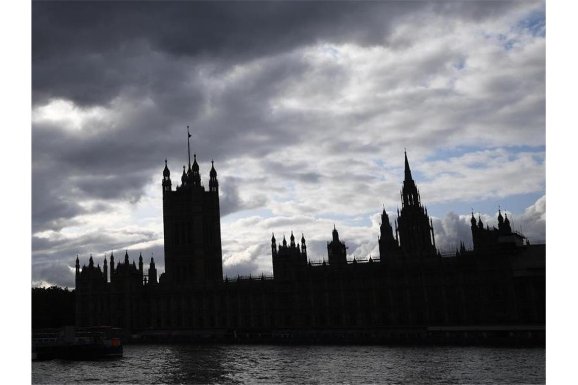 Der Palast von Westminster liegt im Schatten, während dunkle Wolken über dem Parlament aufziehen. Foto: Victoria Jones/PA Wire/dpa