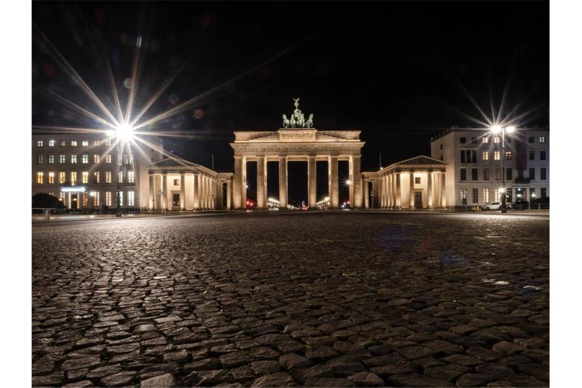 Der Pariser Platz vor dem Brandenburger Tor ist am Abend menschenleer. Foto: Paul Zinken/dpa