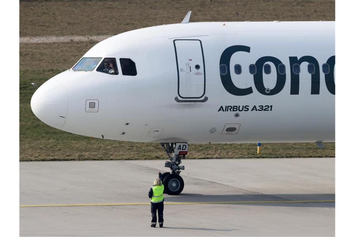 Neuer Eigentümer steigt beim Ferienflieger Condor ein Der Pilot einer Condor-Maschine mit Ziel Teneriffa winkt dem Bodenpersonal vor dem Start vom Flughafen Leipzig/Halle. Foto: Jan Woitas/dpa-Zentralbild/dpa