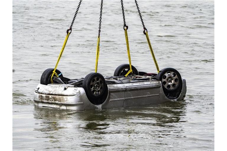 Der Pkw wird in Wesel aus dem Wasser gezogen. Der Wagen mit fünf Insassen war in den Rhein gestürzt, zwei Menschen überlebten. Foto: Arnulf Stoffel/dpa
