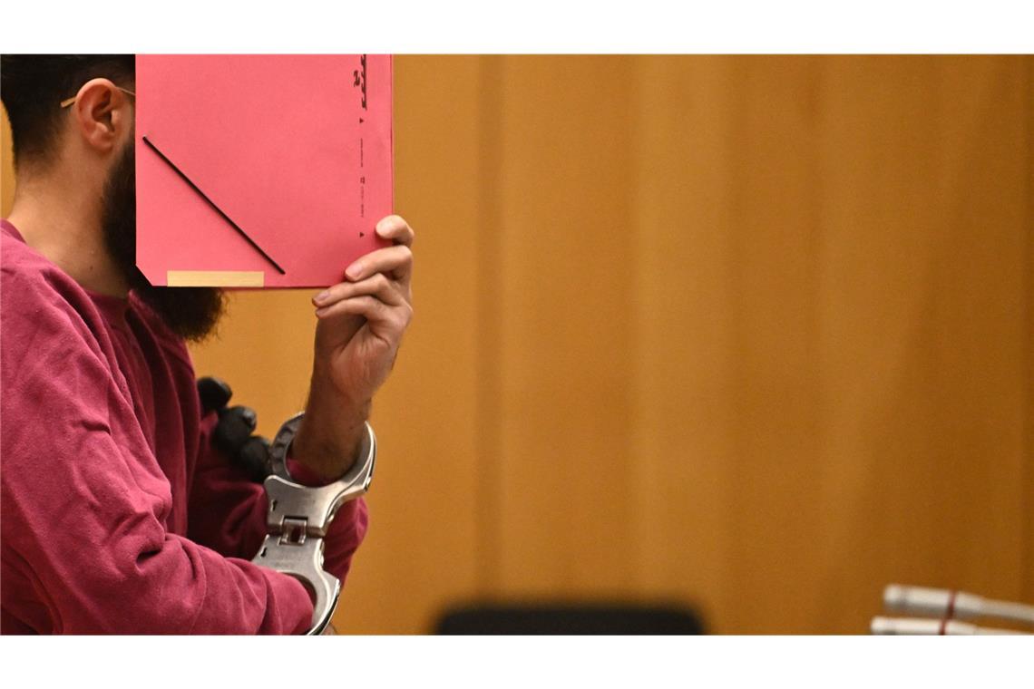 Der Polizistenmörder Sulaiman A. versteckt an einem Prozesstag vor dem Stuttgarter Oberlandesgericht sein Gesicht hinter einer Mappe.