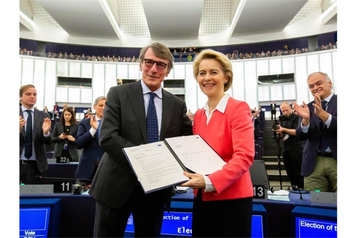 Der Präsident des Euopäischen Parlaments, David Sassoli, überreicht Ursula von der Leyen die Entscheidung des Parlaments zur Bestätigung ihrer Kommission. Foto: Philipp von Ditfurth/dpa