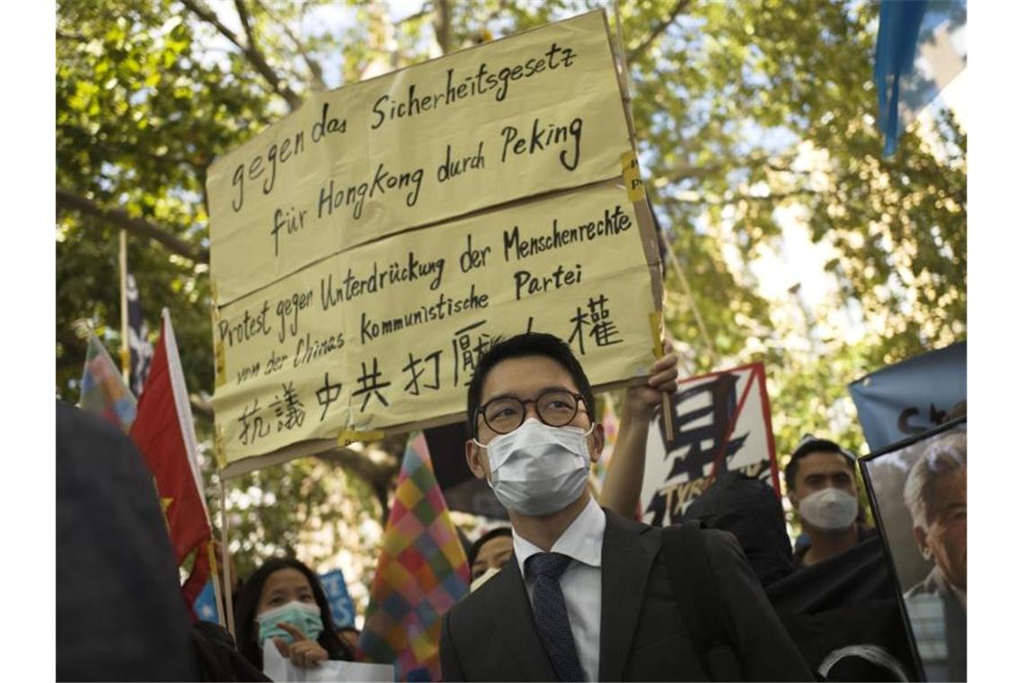 Der pro-demokratische Aktivist Nathan Law (M) nimmt an einem Protest gegen die chinesische Führung in Berlin teil. Foto: Markus Schreiber/AP/dpa