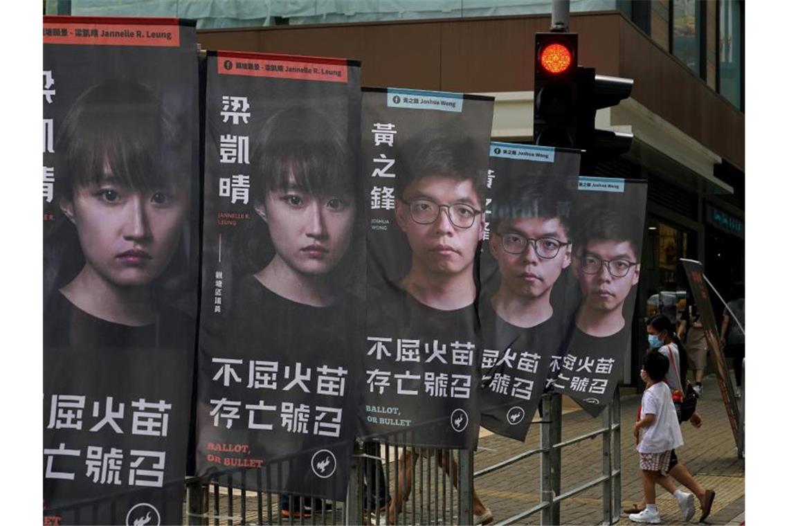 Schwerer Schlag gegen Opposition: 50 Festnahmen in Hongkong Der prominente Aktivist Joshua Wong (auf den hinteren drei Bannern zu sehen) sitzt wegen des Vorwurfs der illegalen Organisation eines Protests im Gefängnis. Foto: Kin Cheung/AP/dpa