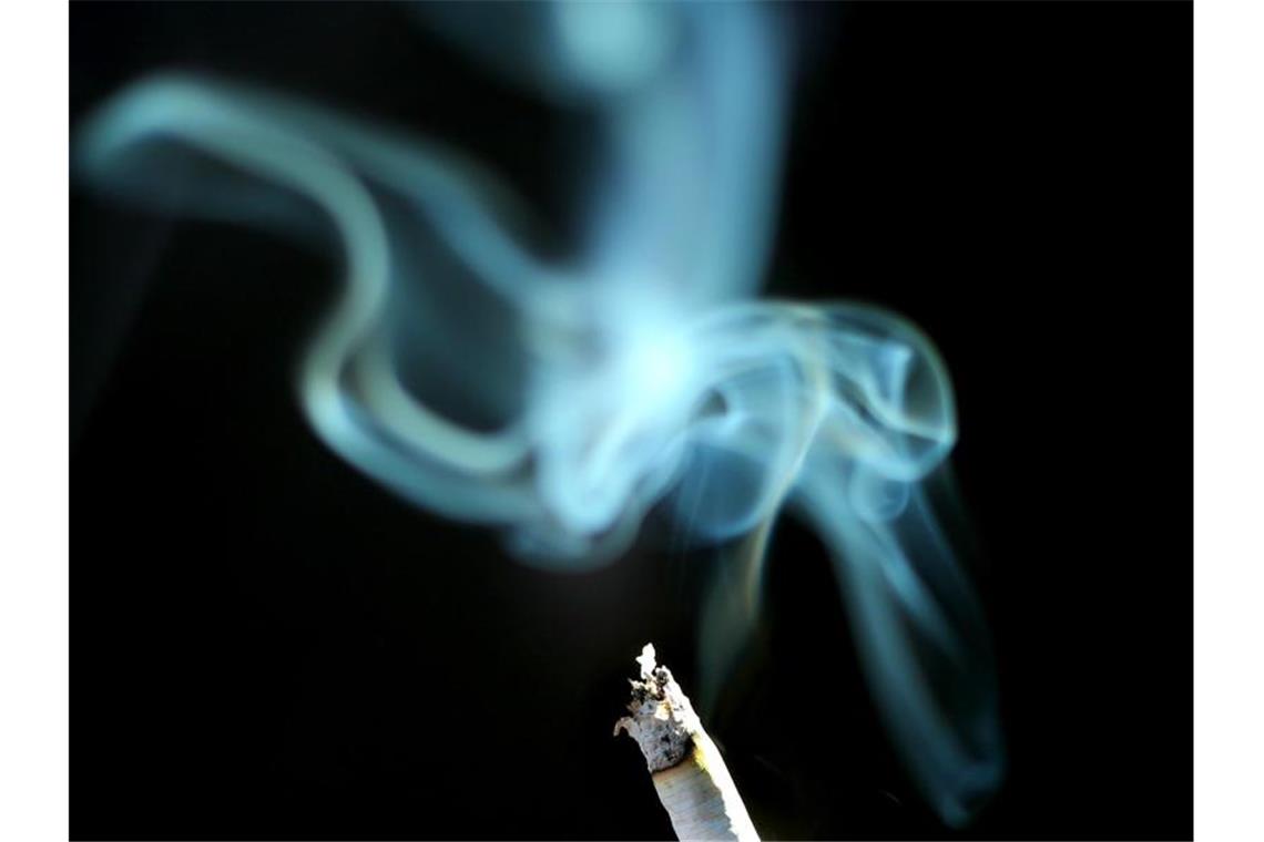 Der Rauch einer brennenden Zigarette. Foto: Karl-Josef Hildenbrand/Archivbild