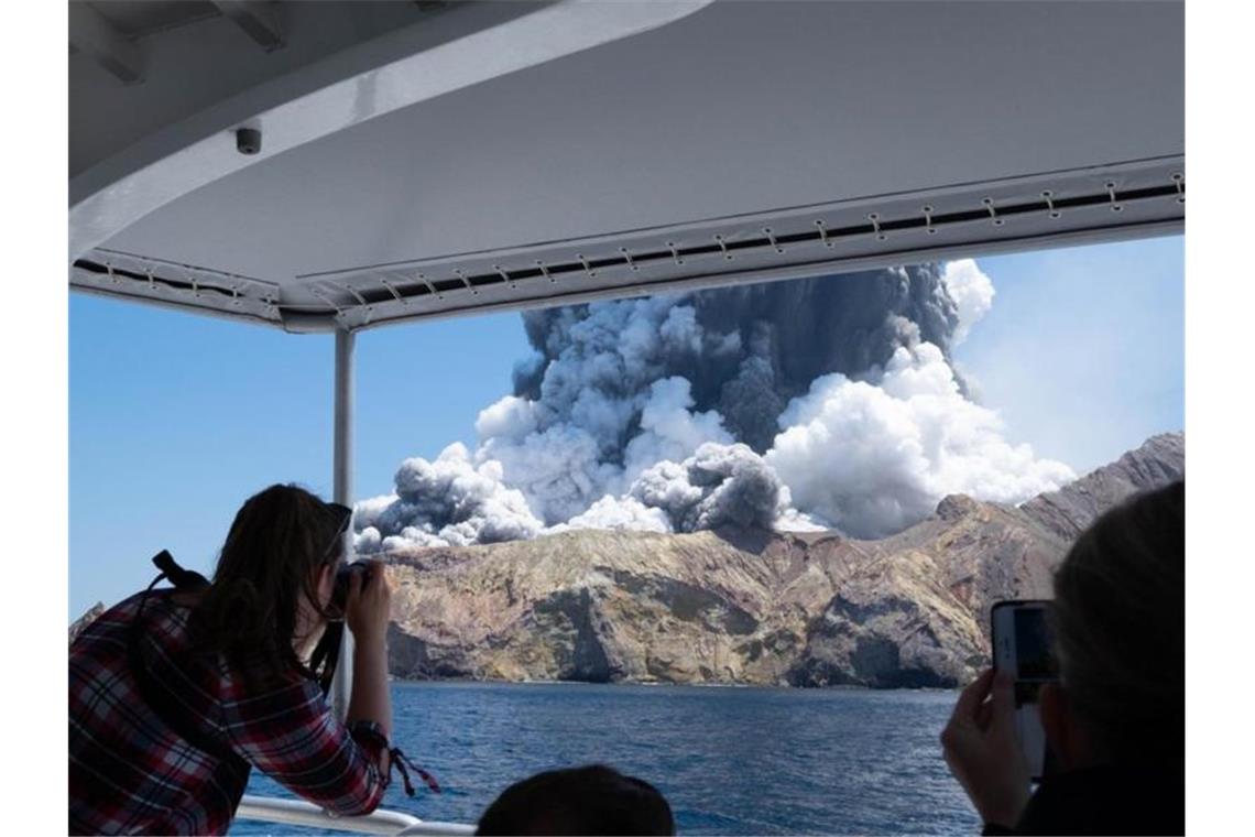 Ein Jahr nach Vulkanausbruch in Neuseeland Der rauchende Vulkan auf der White Island. Fast ein Jahr nach dem verheerenden Vulkanausbruch gedenkt Neuseeland der Toten. Foto: Michael Schade/XinHua/dpa