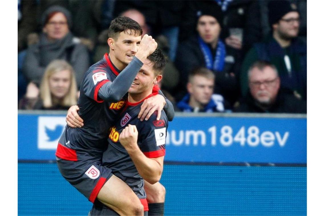 Führungstrio schwächelt - Trainerdiskussion beim VfB Der Regensburger Torschütze zum 3:1 Sebastian Stolze (l) jubelt mit Andreas Albers. Foto: Roland Weihrauch/dpa