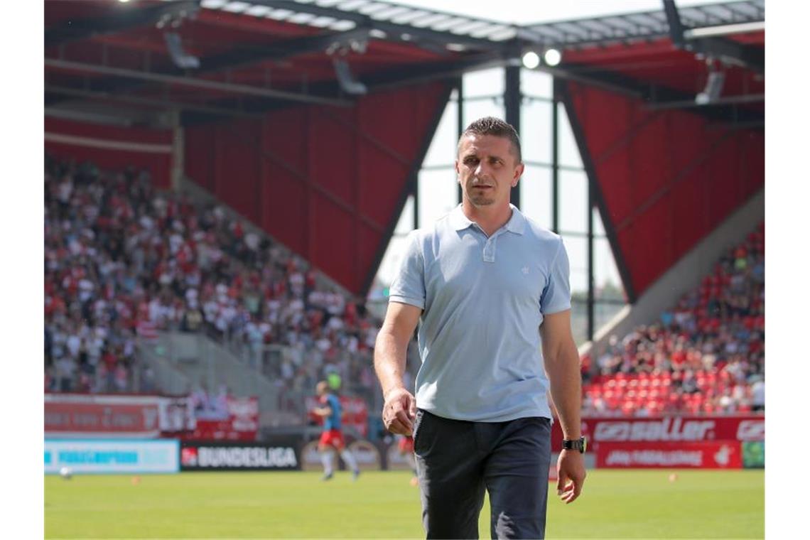 Der Regensburger Trainer Mersad Selimbegovic geht vor Spielbeginn über den Platz. Foto: Daniel Karmann/Archivbild