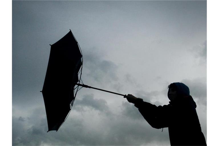 Der Regenschirm eines Spaziergängers wird von einer Windböe erfasst. Foto: picture alliance / Karl-Josef Hildenbrand/dpa/Symbolbild