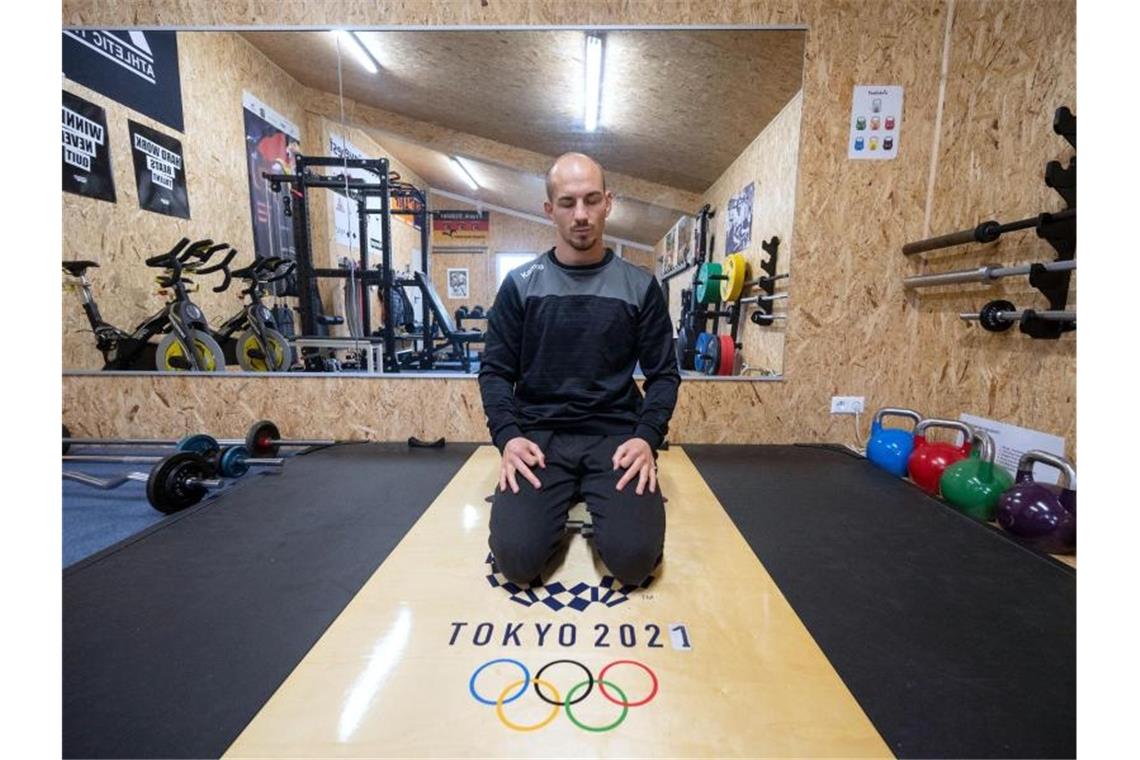 Der Ringer Frank Stäbler sitzt während eines Atemtrainings in einer Meditationsposition in seinem Krafttrainingsraum. Foto: Marijan Murat/dpa/Archivbild