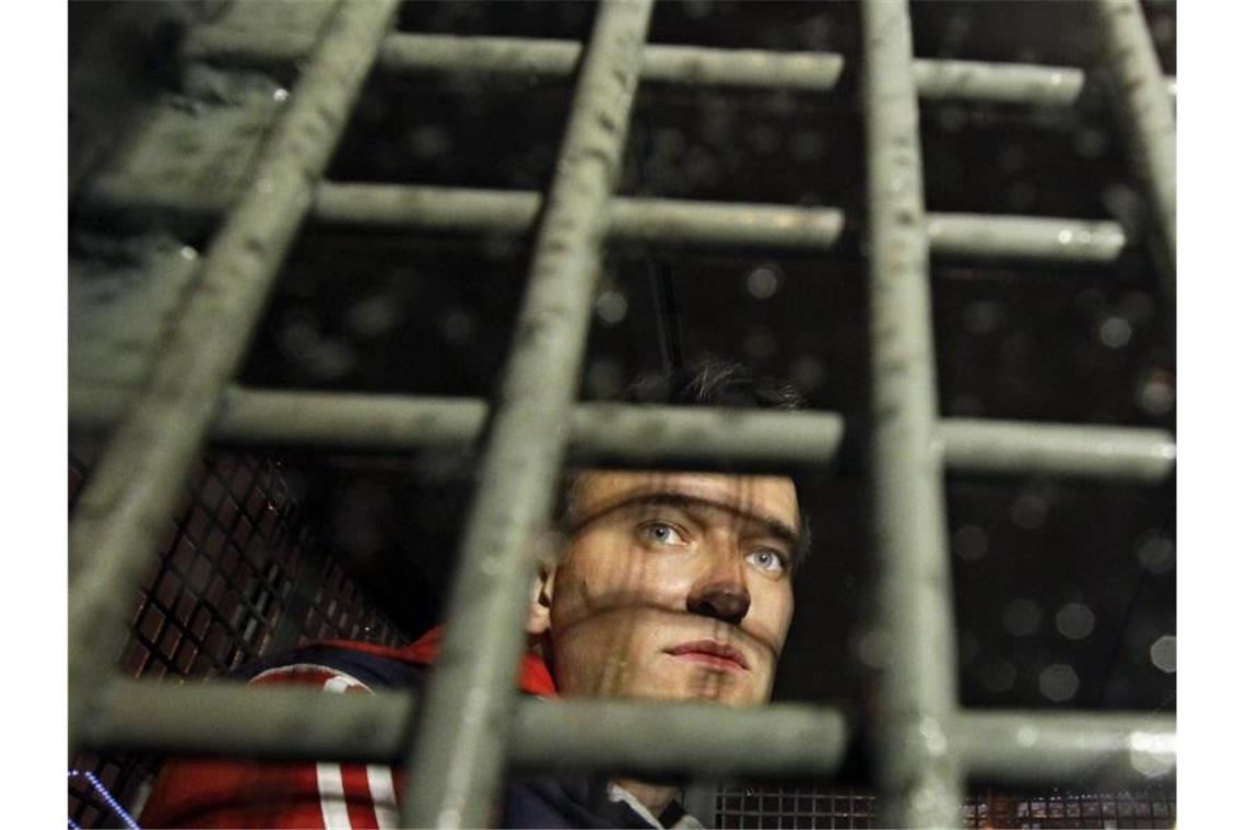 Kremlgegner Nawalny zu neun Jahren Straflager verurteilt Der russische Oppositionelle Alexej Nawalny ist hinter Gittern eines Polizeiwagens zu sehen. Foto: Sergey Ponomarev/AP/dpa