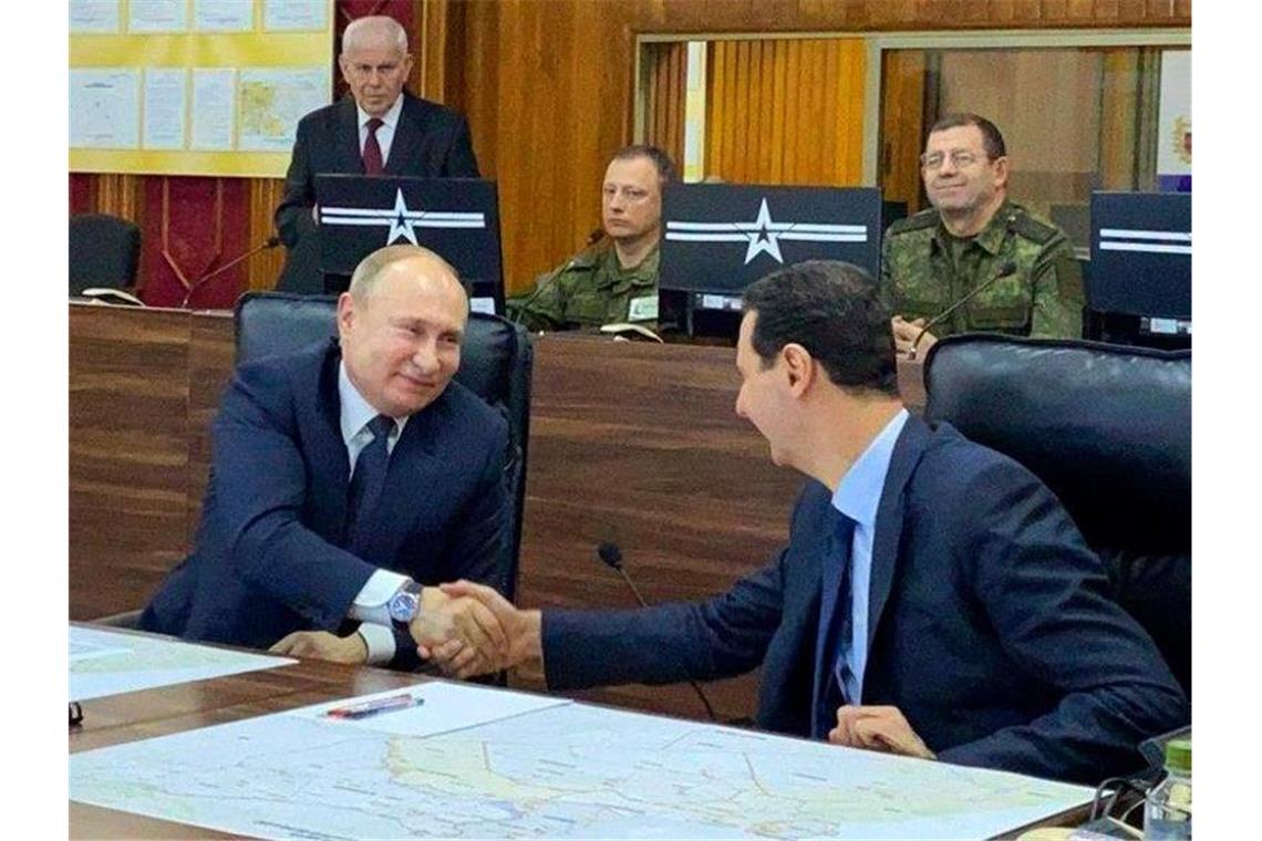 Geschenk für Assad: Putin überraschend in Damaskus Der russische Präsident Wladimir Putin (l) trifft in Damaskus auf seinen syrischen Amtskollegen Baschar al-Assad (M). Foto: Uncredited/Syrian Presidency/dpa