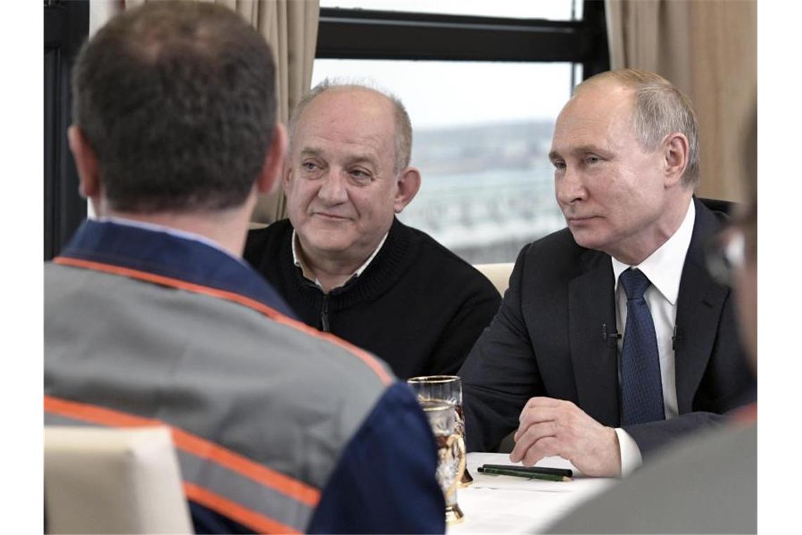Putin gibt umstrittene Krim-Brücke für Zugverkehr frei Der russische Präsident Wladimir Putin unterhält sich mit Arbeitern und Ingenieuren, während er per Zug über die neue 19 Kilometer lange Krim-Brücke fährt. Foto: Alexei Nikolsky/Pool Sputnik Kremlin/AP/dpa