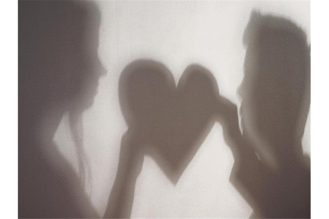 Verbraucherzentrale: Partnerbörsen-Siegel oft zweifelhaft Der Schatten einer Frau und eines Mannes, die gemeinsam ein Herz halten, ist an eine Wand geworfen. Foto: Jan-Philipp Strobel/dpa/Symbolbild