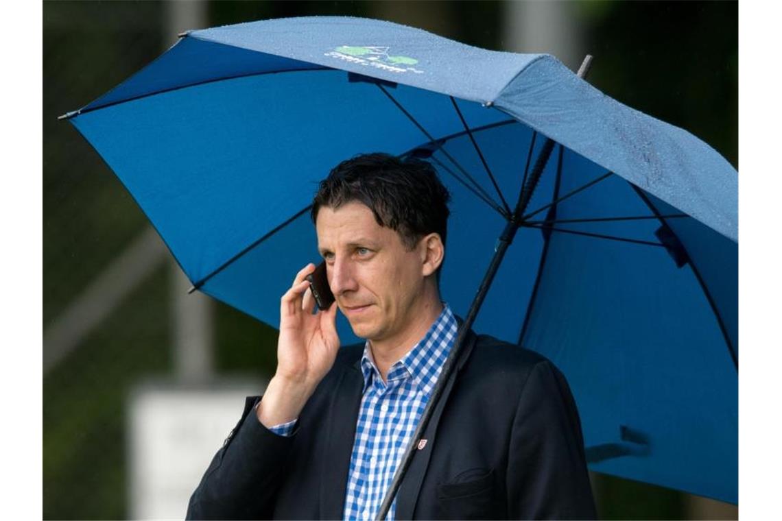 Der scheidende Geschäftsführer Christian Keller vom SSV Jahn Regensburg telefoniert. Foto: picture alliance / Armin Weigel/dpa