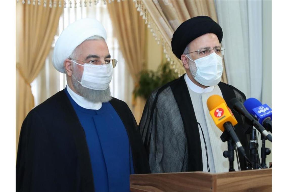 Der scheidende iranische Präsident Hassan Ruhani (l) tritt mit seinem gewählten Nachfolger Ebrahim Raeissi vor die Presse. Foto: -/Iranian Presidency/dpa