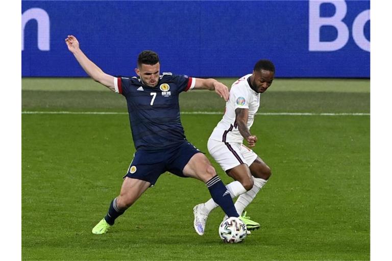 Der Schotte John McGinn (l) ist im Zweikampf vor Raheem Sterling am Ball. Foto: Facundo Arrizabalaga/Pool EPA/AP/dpa
