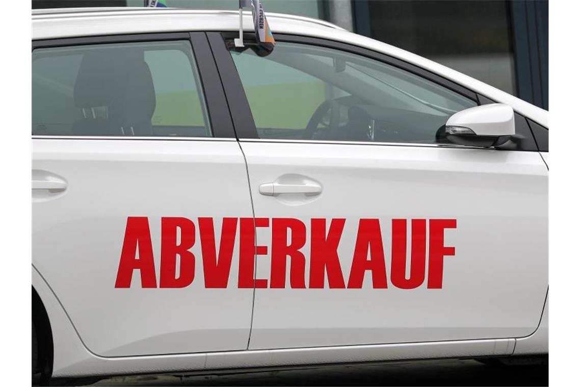 Der Schriftzug „Abverkauf“ steht auf einem weißen Toyota vor einem Autohaus. Foto: Jan Woitas/zb/dpa