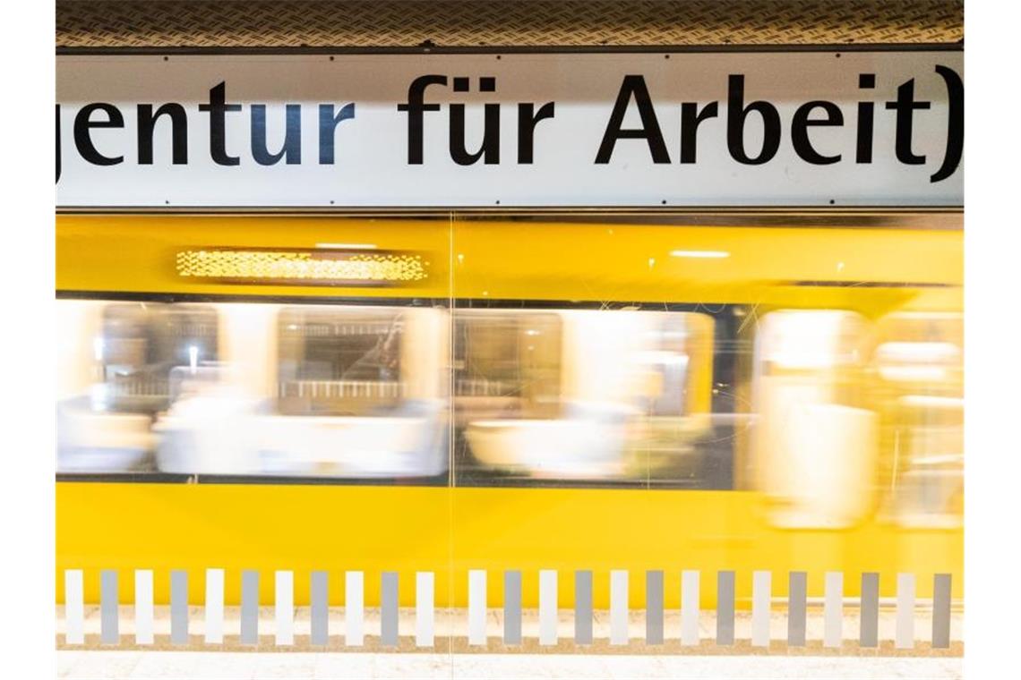 Unsicherheit auf dem deutschen Arbeitsmarkt nimmt zu Der Schriftzug "„Agentur für Arbeit“" steht am frühen Morgen an einer Stuttgarter Haltestelle geschrieben, während im Hintergrund eine Stadtbahn einfährt. Foto: Christoph Schmidt/dpa
