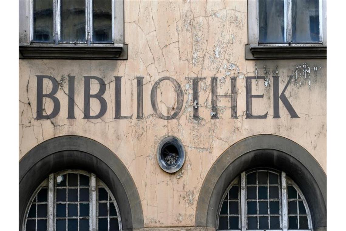 Bücher in Quarantäne: Bibliotheken in Zeiten von Corona Der Schriftzug "Bibliothek" blättert von einer Fassade. Foto: Hendrik Schmidt/dpa-Zentralbild/ZB/Symbolbild