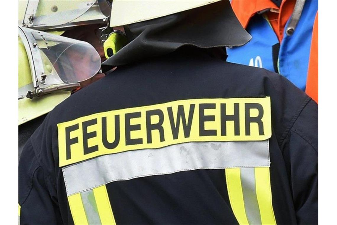 Ehepaar verletzt sich bei Küchenbrand Der Schriftzug Feuerwehr steht an der Jacke eines Feuerwehrmannes. Foto: picture alliance / dpa/Symbolbild